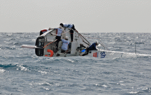 J/24 Island Water World Die Hard crew struggle to right the boat after a capsize in today’s windy race.